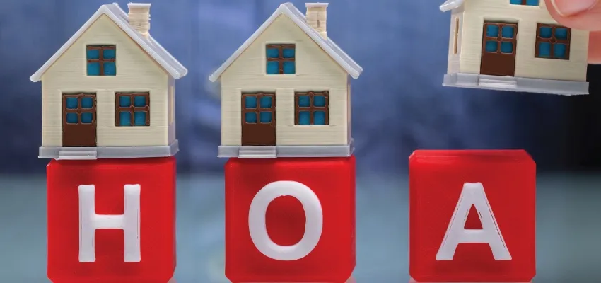 Toy houses standing on red blocks that spell HOA