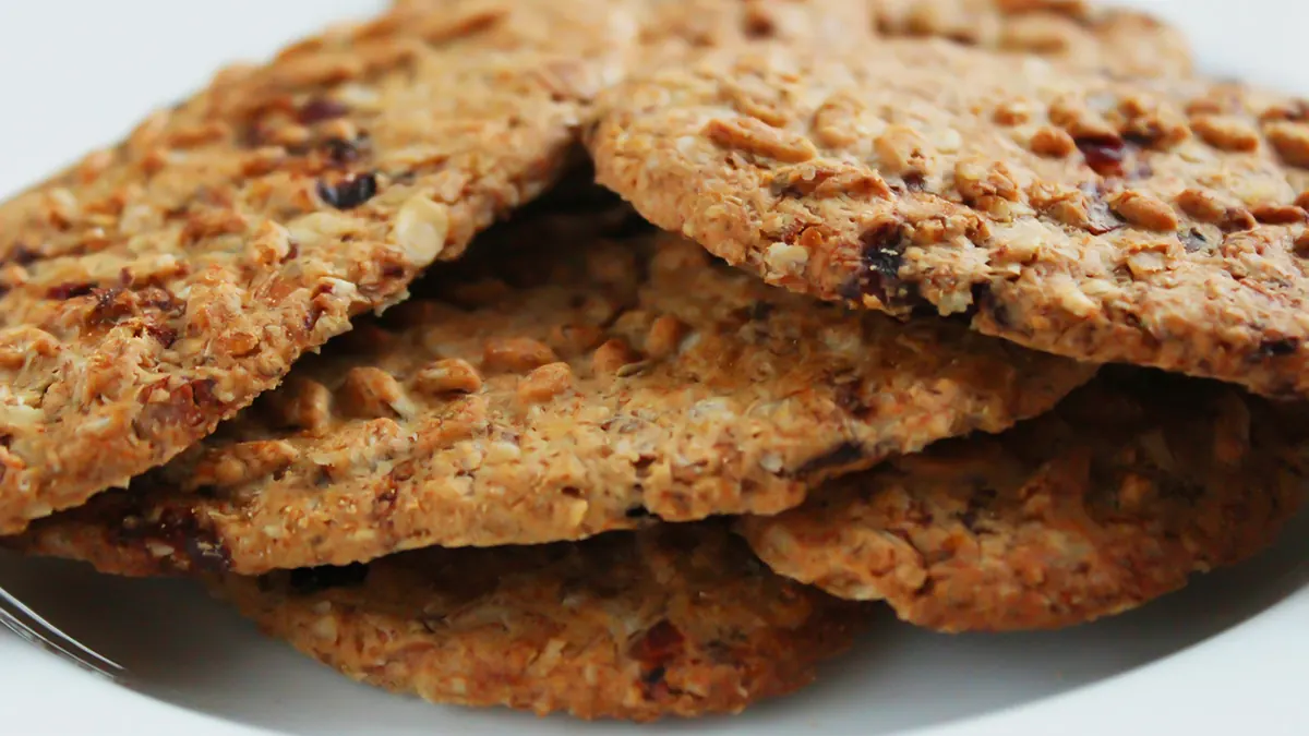 Round oat cookies with seeds piled on a white plate