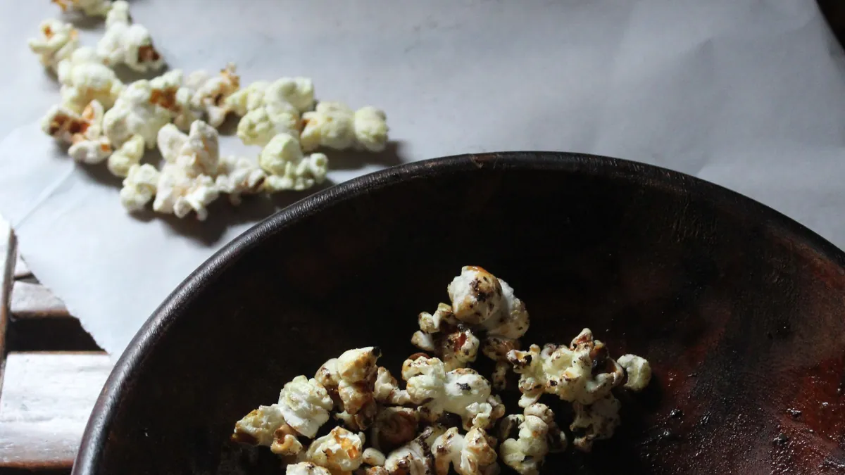 Popcorn in a dark bowl on parchment paper