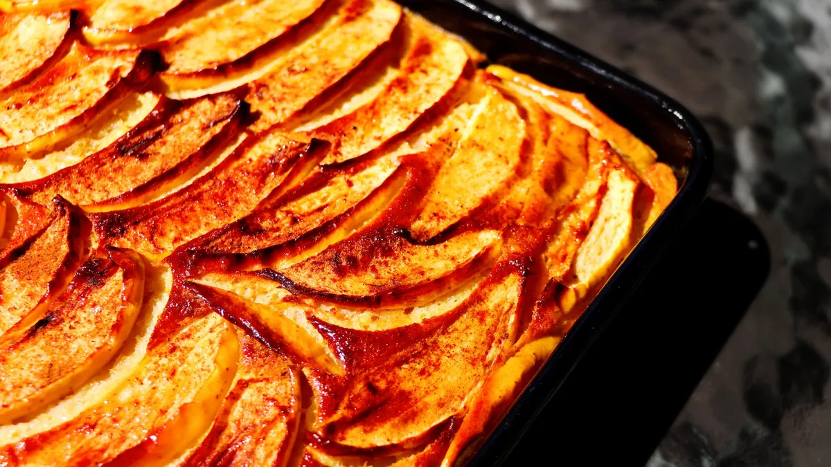 Apple cinnamon cake topped with overlapping baked apple slices