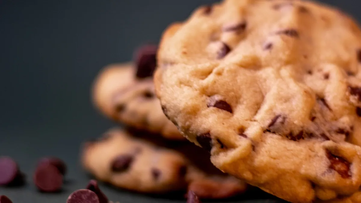 Chocolate chip cookies stacked on a dark table
