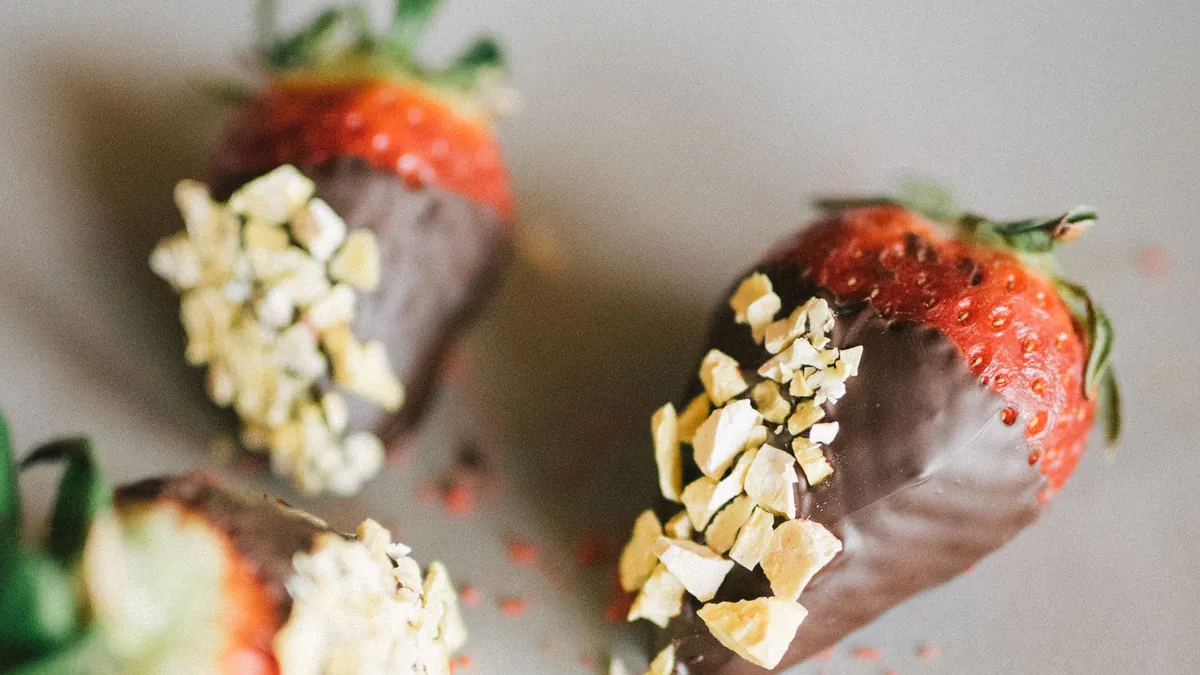 Chocolate-covered strawberries with chopped nuts on a plate
