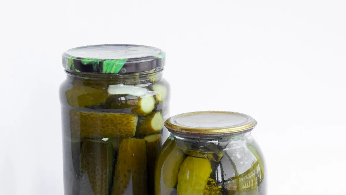 Two glass jars of pickled cucumbers