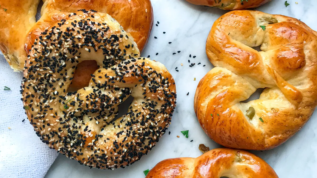 Freshly baked pretzels and sesame bagels on a marble table