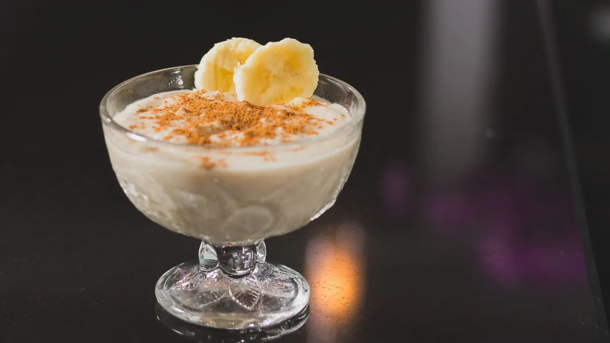 Creamy banana dessert with banana slices in a glass dish