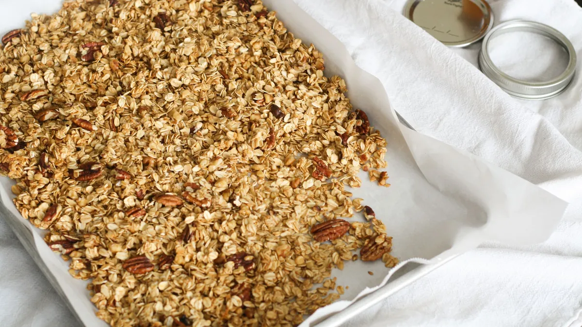 Homemade granola with pecans baked on a tray lined with parchment paper