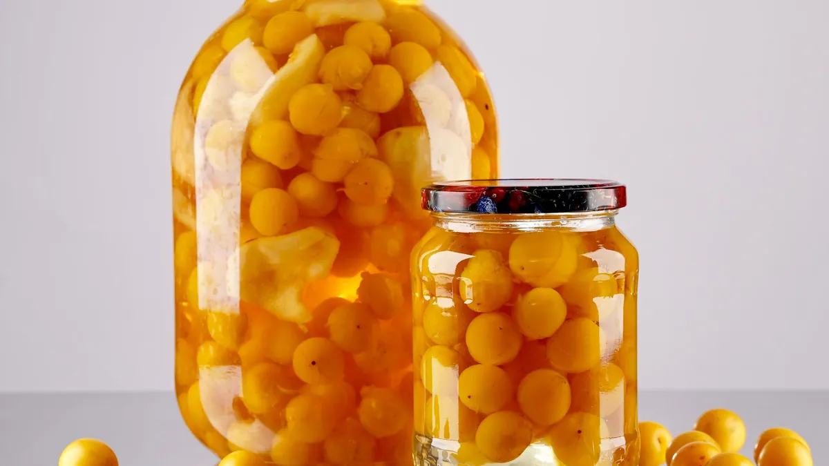 Two glass jars of preserved yellow plums