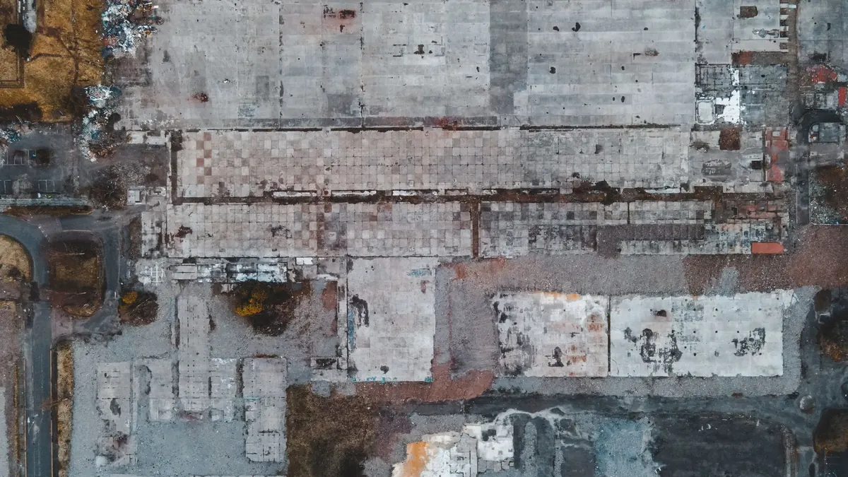 Aerial view of a vacant lot with concrete slabs and debris